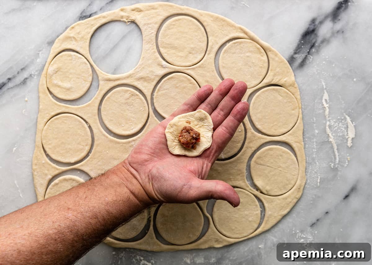 overhead: adding savory meat filling to the center of a dough circle