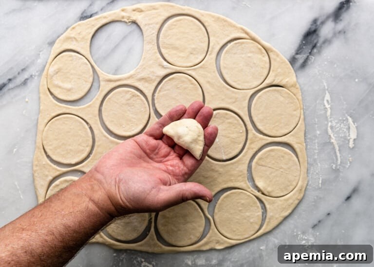 overhead: folding over dough for shish barak, forming a half-moon shape