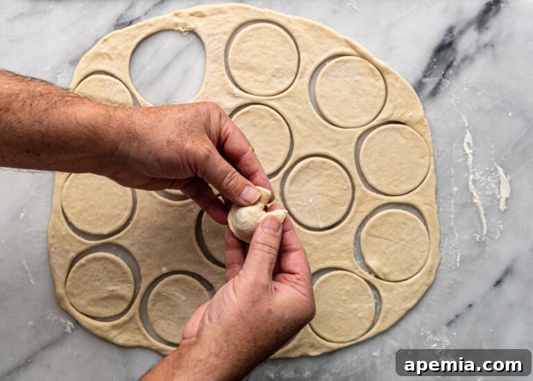 overhead: pinching the ends of dough together to create a tortellini-like shape