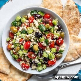 Overhead image: pita bread surrounds Greek feta salad on white plate