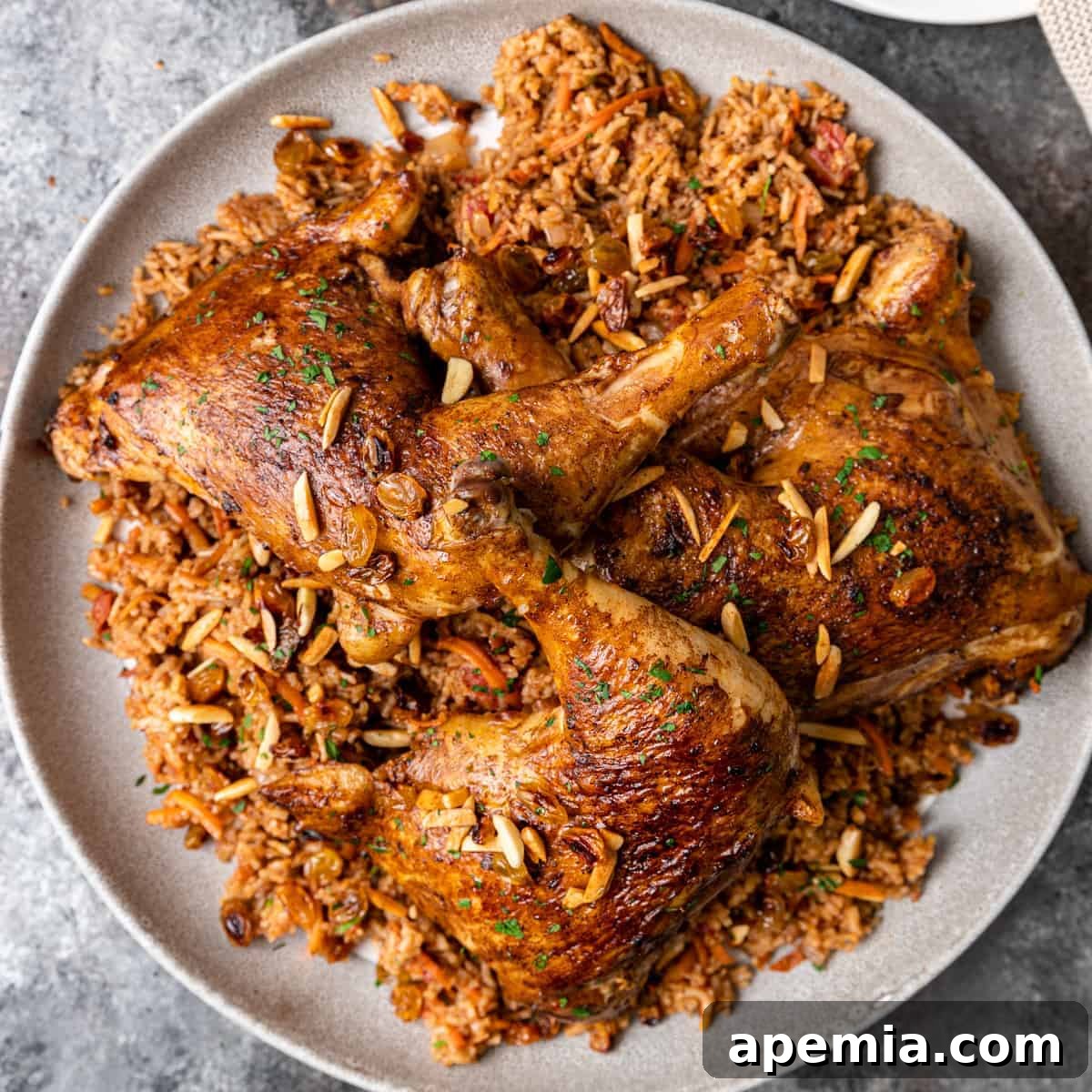 Overhead shot of a beautifully presented plate of crispy, golden Kabsa, garnished with fresh herbs and nuts.