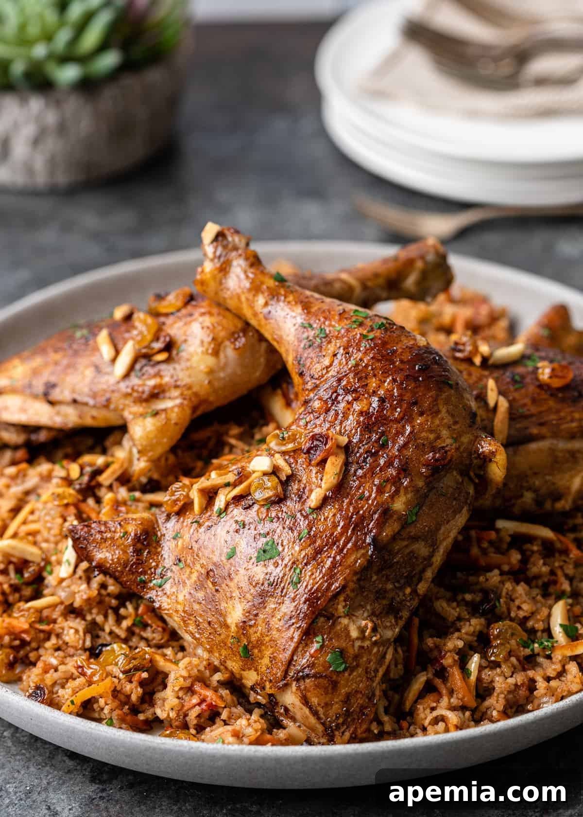 Side view of a large platter of my homemade Kabsa recipe, featuring tender chicken pieces nestled on a bed of aromatic rice.