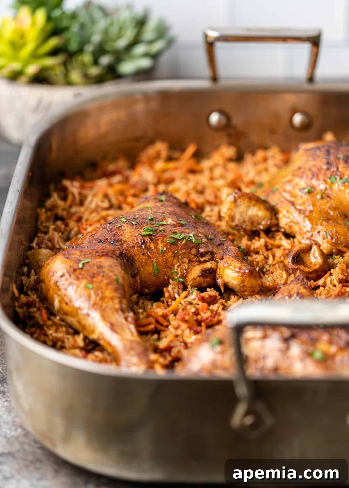 A large roasting pan filled with perfectly cooked Arabic chicken and rice (Kabsa), ready to be served.