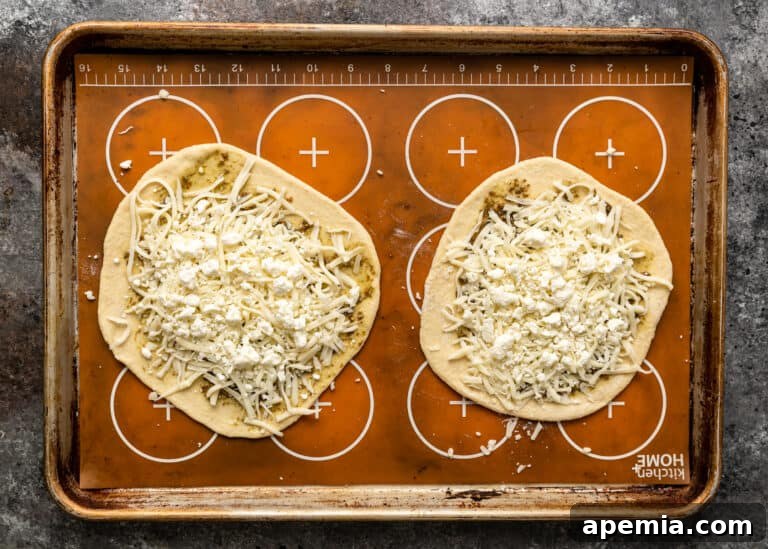 two unbaked manakish on a baking sheet