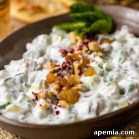 Persian Yogurt and Cucumber Dip (Mast o Khiar) in bowl topped with golden raisins and walnuts