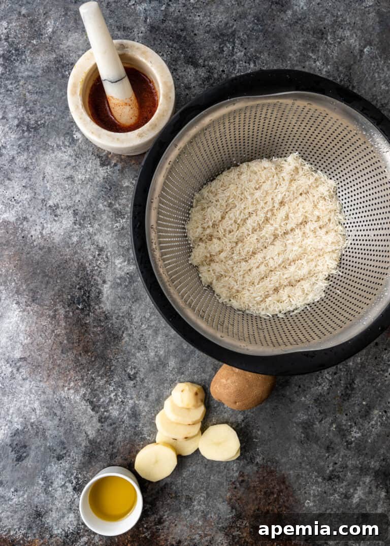 overhead: rice in steamer basket next to potato slices and Persian spices