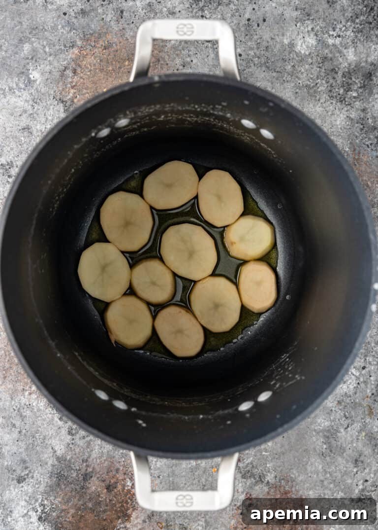 overhead process shot: potato slices in oil for an Iranian rice tahdig