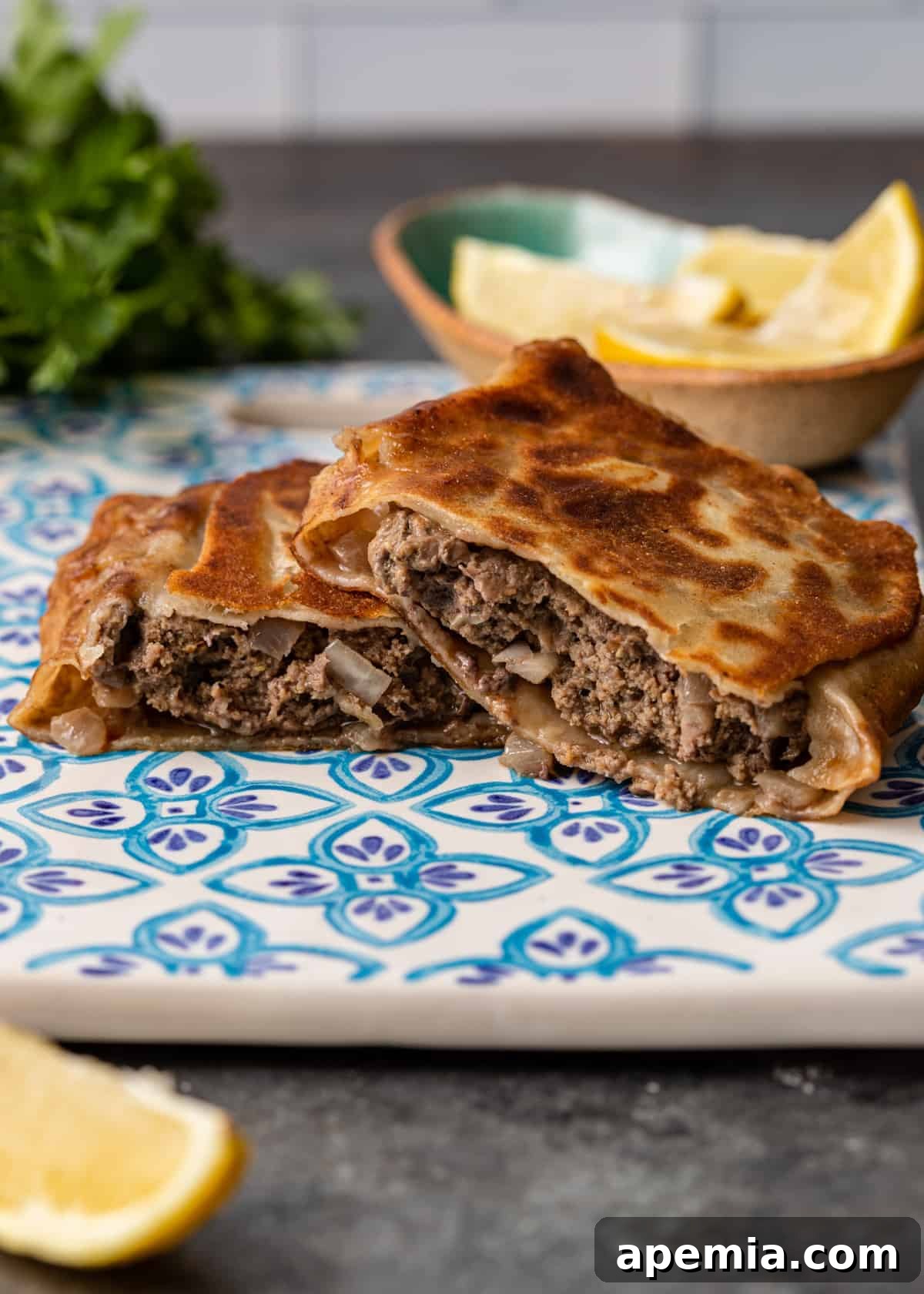 Side view of a meat-filled Turkish Gozleme, sliced in half to reveal the savory filling.