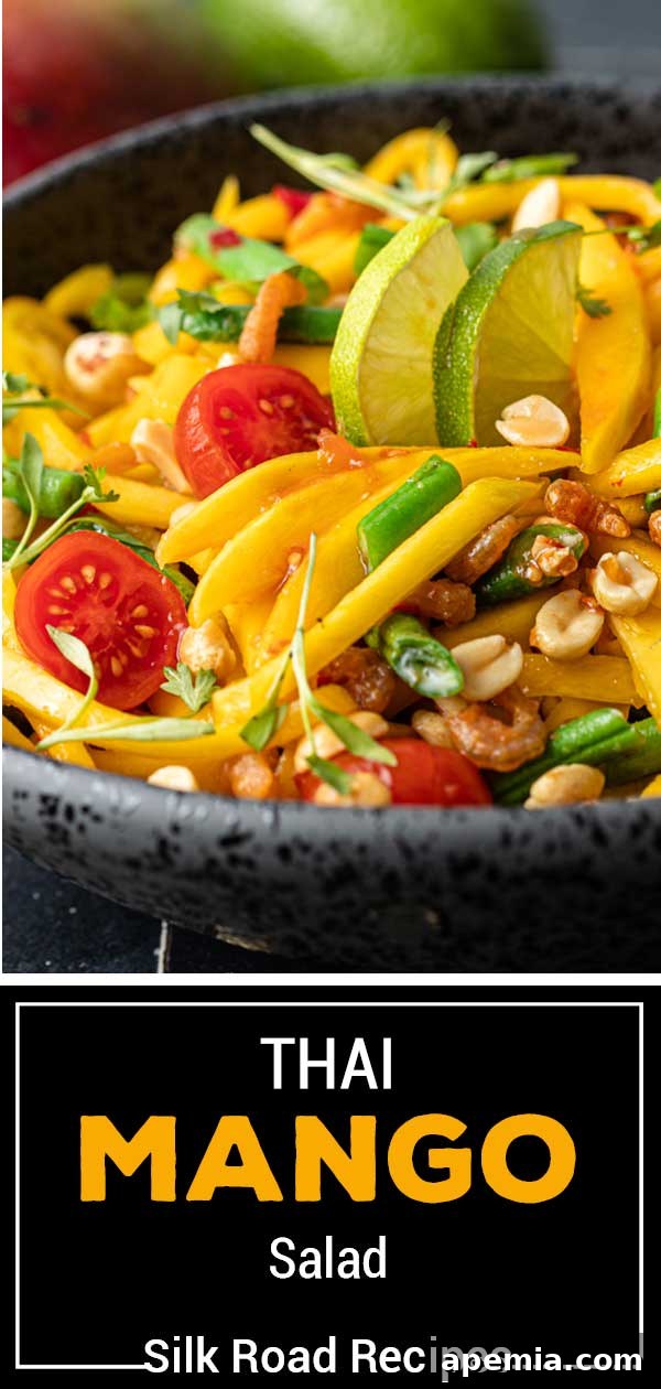 Titled image showing a closeup of the Thai mango salad with Thailand mangoes, cherry tomatoes, green beans, and peanuts.