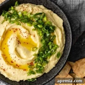 close up overhead image: bowl of Greek mashed potatoes garnished with scallions
