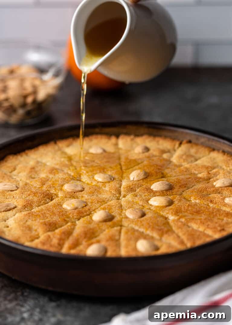 Egyptian Basbousa Golden Semolina Bliss 11 Side view of the golden Basbousa cake being generously drenched with a sweet orange blossom water and sugar glaze, soaking into its porous surface.