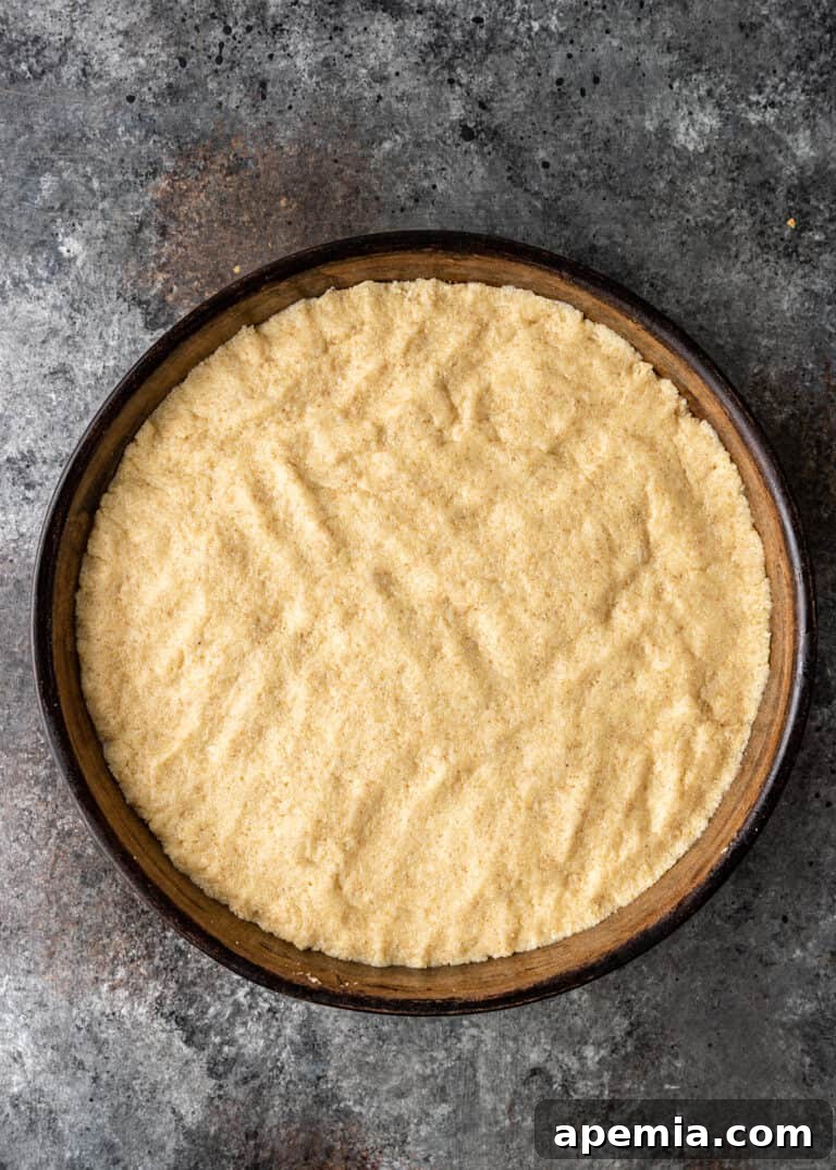 Egyptian Basbousa Golden Semolina Bliss 6 Overhead view of the semolina cake batter evenly pressed into a round cake pan, ready for baking.
