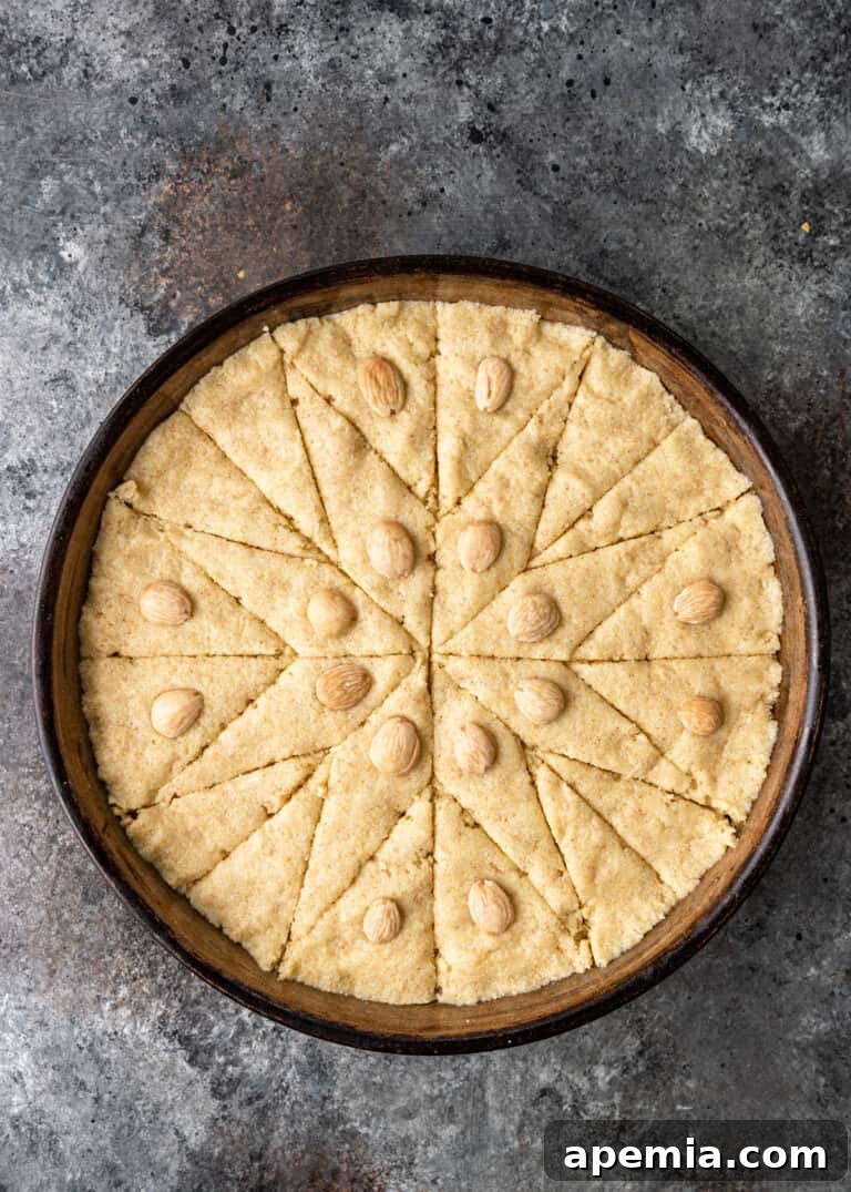 Egyptian Basbousa Golden Semolina Bliss 8 Overhead view of the star design intricately cut into the Basbousa cake batter, adorned with almonds, prior to baking.