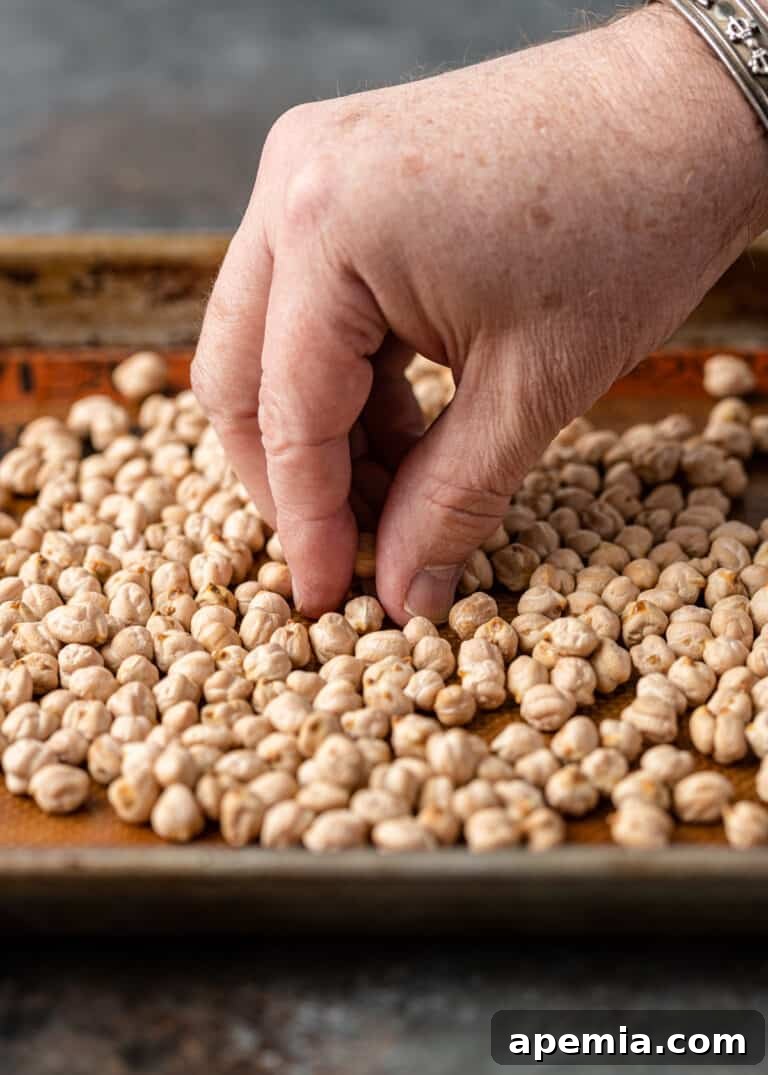 Another view of hand sorting dried garbanzo beans, illustrating the careful inspection process