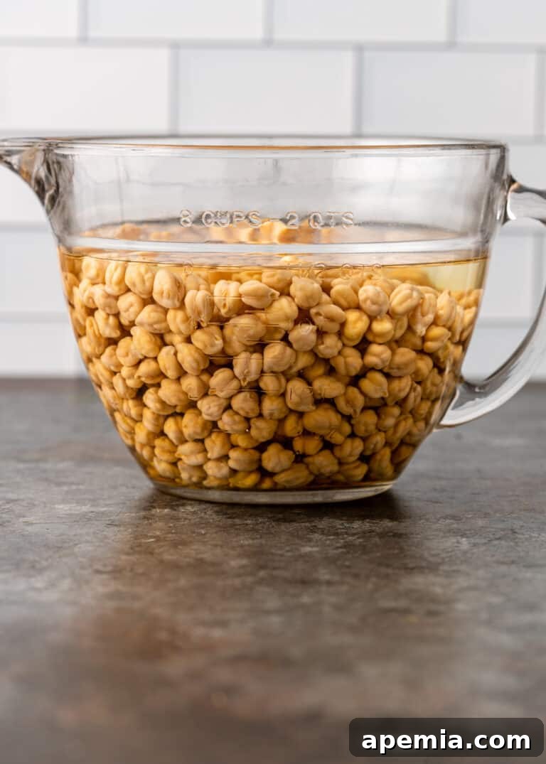 Chickpeas soaking in water, showing the rehydration process, the second step in cooking