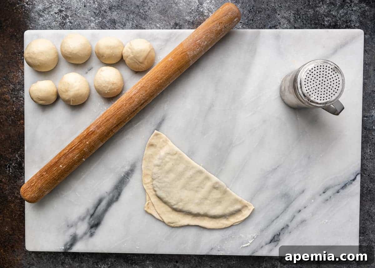 overhead image: balls of hand pie dough and rolling pin on marble pastry board
