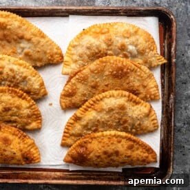 perfectly golden brown fried cheburek on baking sheet lined with paper toweling