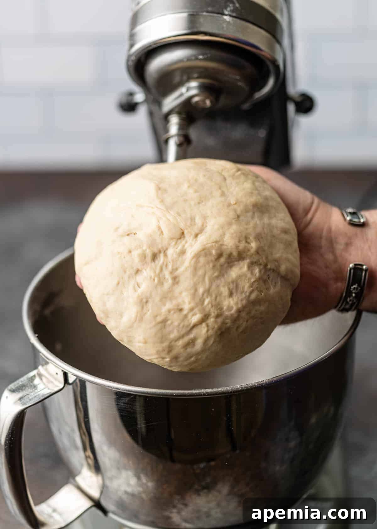 man's hand holding large ball of homemade pie dough