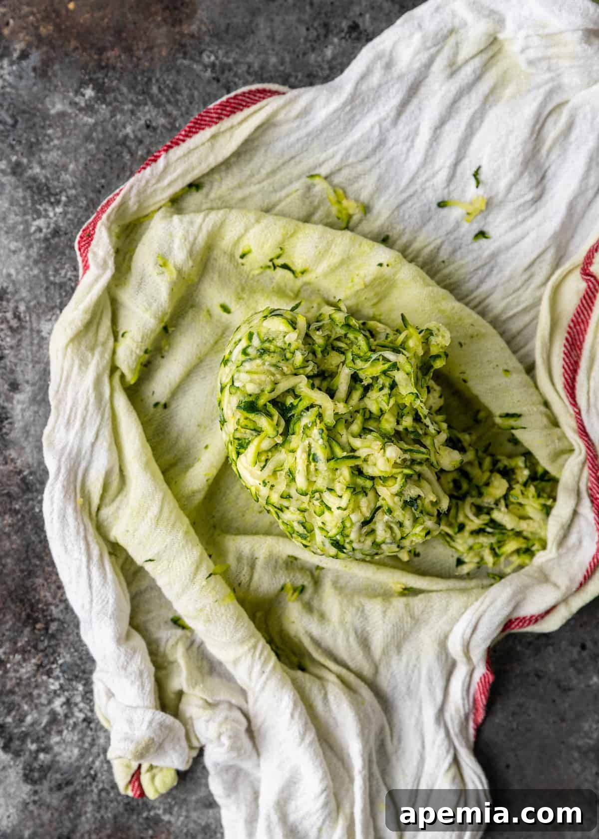 squeezing water from shredded zucchini to make fried squash patties