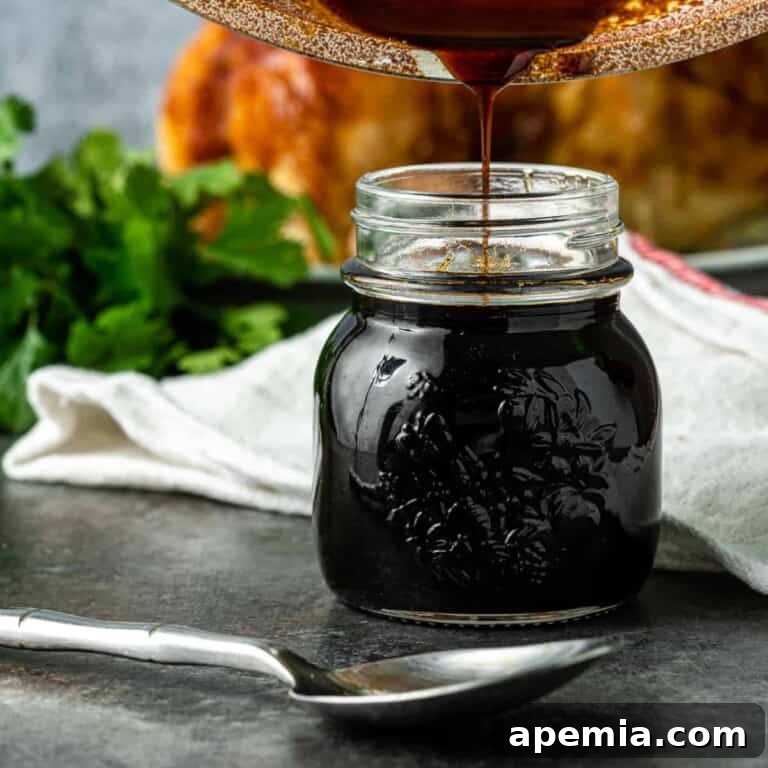 Tropical Pineapple Teriyaki 2 Freshly made pineapple teriyaki sauce being poured into a small glass jar, ready for use or storage.
