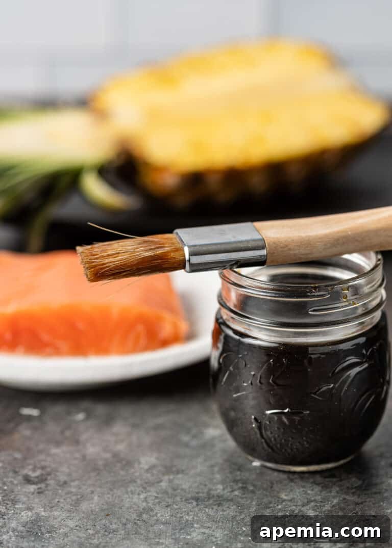 Tropical Pineapple Teriyaki 3 Small glass jar filled with luscious pineapple teriyaki sauce, accompanied by a basting brush, ready for application.