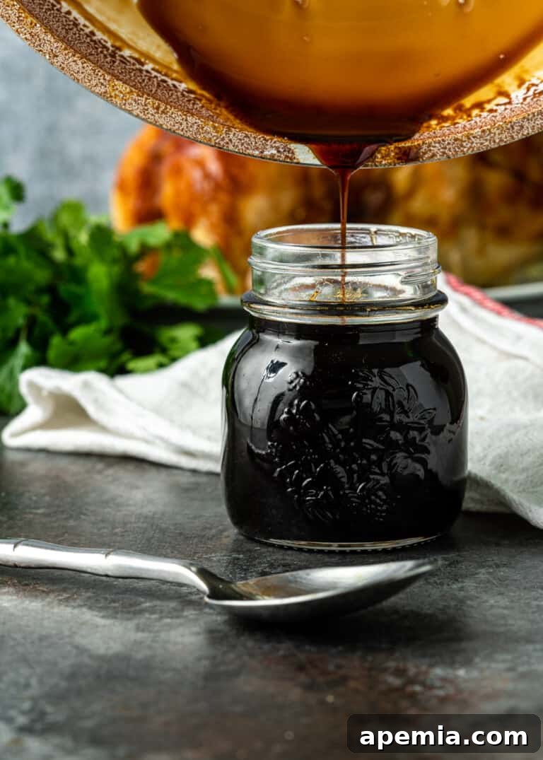 Tropical Pineapple Teriyaki 4 Pouring the amber Japanese sauce into a clear glass canning jar, showcasing its smooth texture.