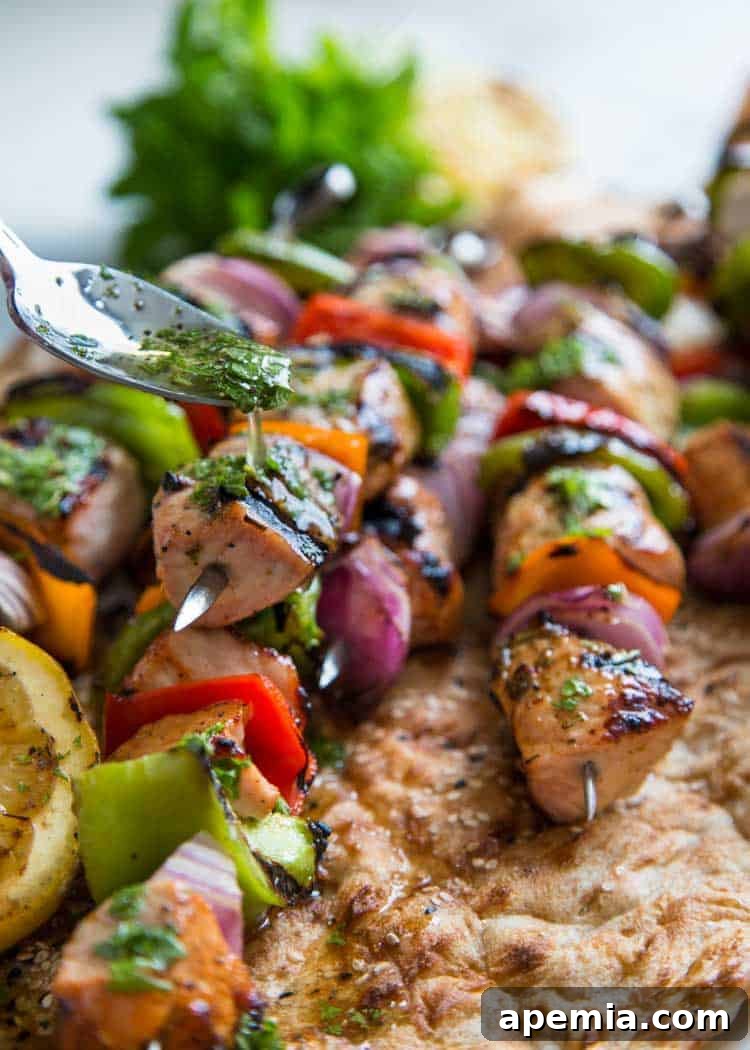 Closeup of honey mint sauce being spooned over shashlik pork kabobs.