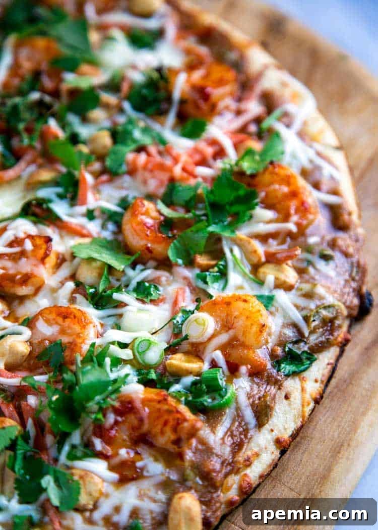 Vibrant Thai Shrimp Pizza 3 Overhead shot of half a Thai pizza generously topped with shrimp satay, capturing its inviting appeal before being sliced.