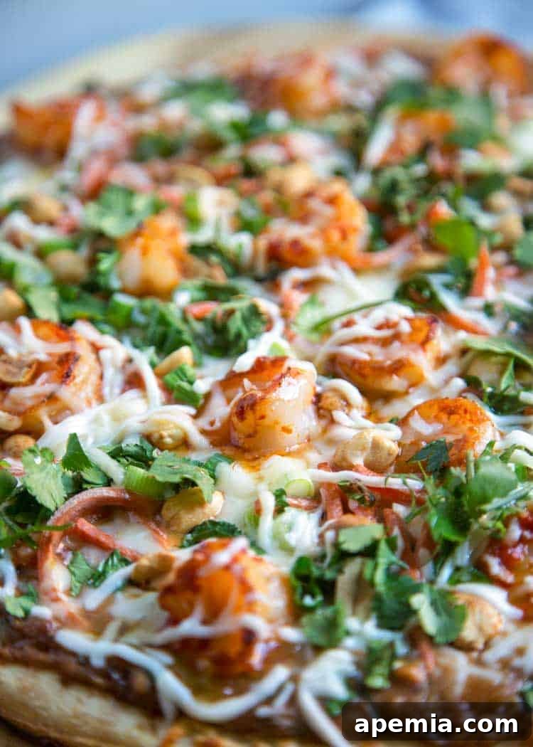 Vibrant Thai Shrimp Pizza 7 A close-up image of the spicy seafood pizza, highlighting the generously layered shrimp, melted cheeses, and vibrant garnishes.