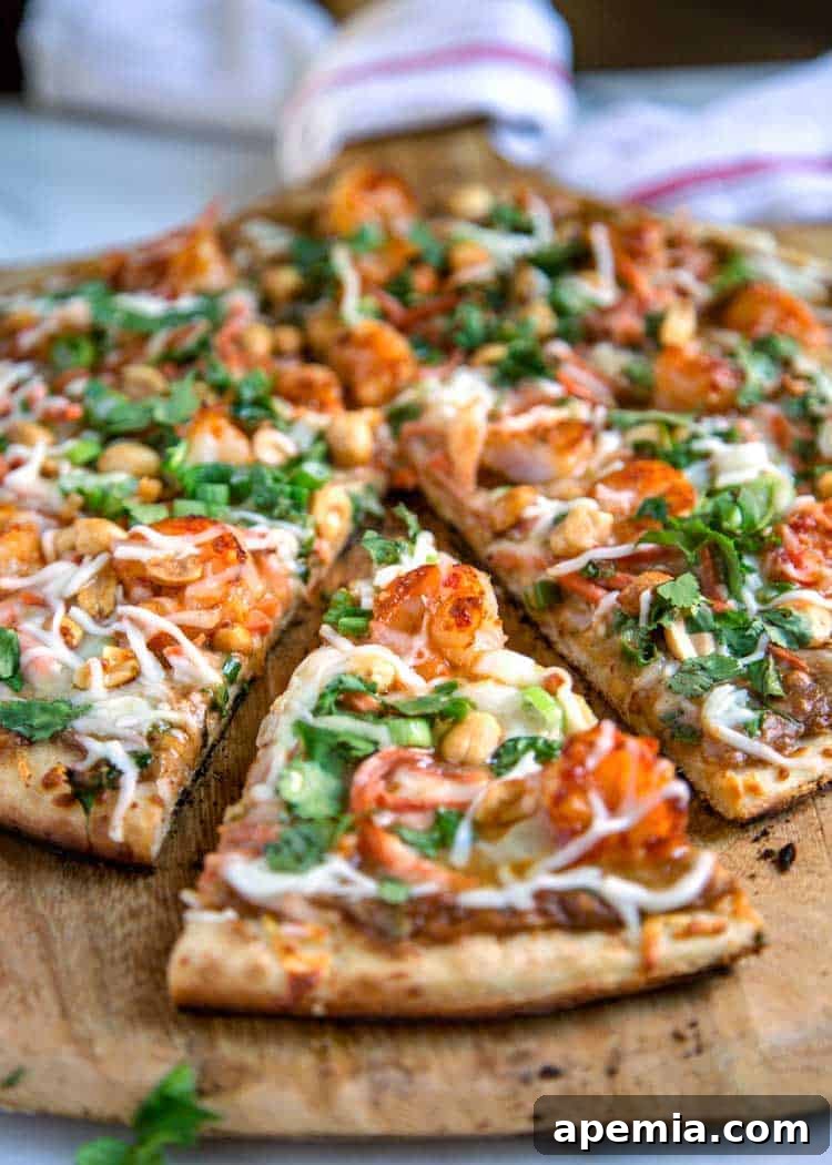 Vibrant Thai Shrimp Pizza 8 Sweet and spicy shrimp pizza cut into perfectly triangular slices, elegantly arranged on a rustic wood pizza peel, ready for serving.