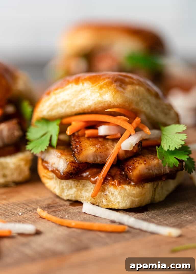 Extremely close-up shot of a gourmet fried pork belly slider sandwich, showcasing its layers.
