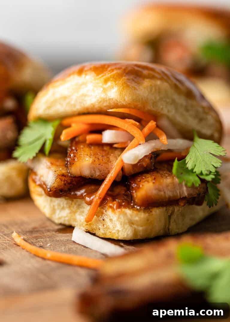 A delectable closeup of a freshly made fried pork belly sandwich on a soft bun, ready to be enjoyed.