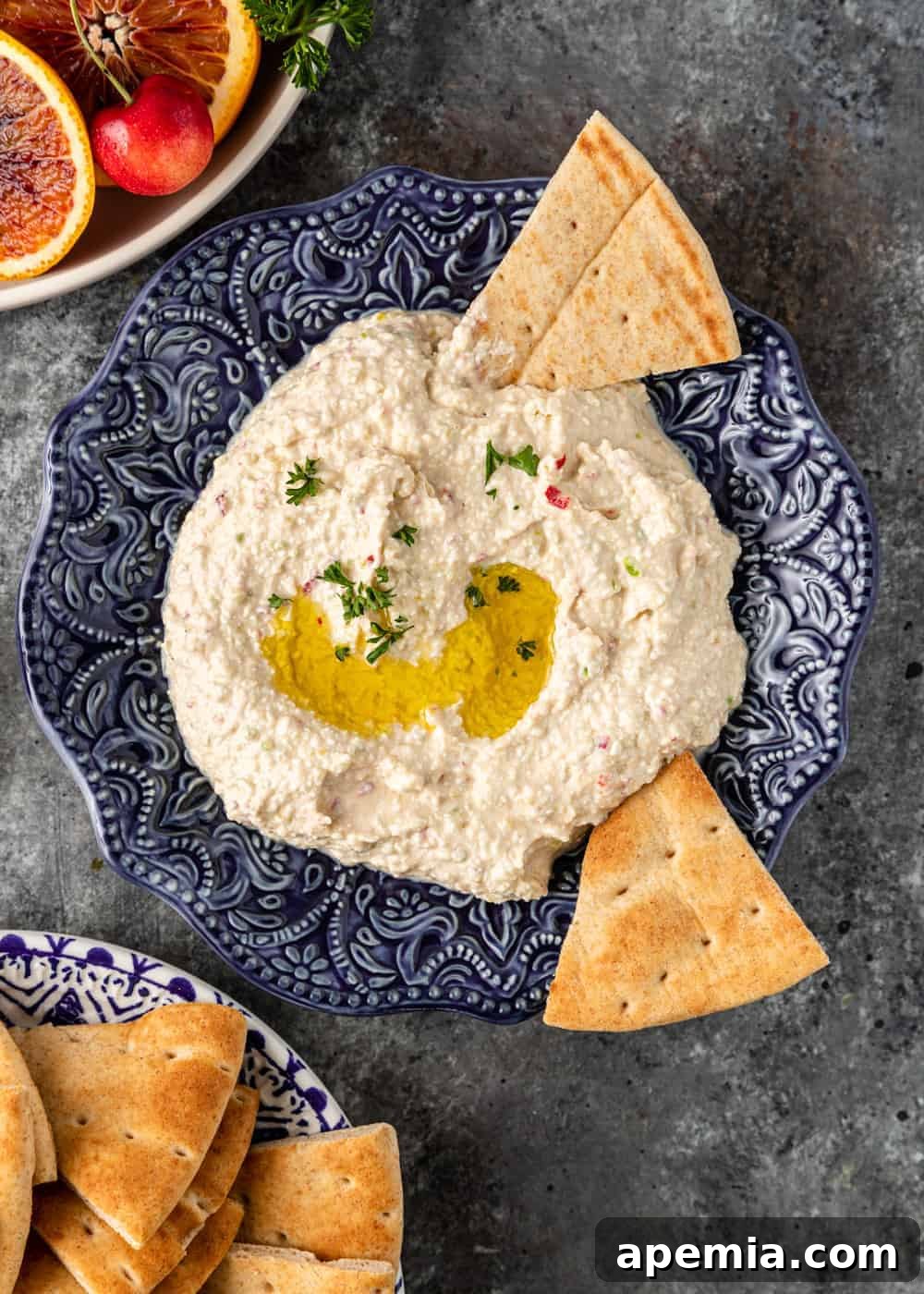 Fiery Feta Dip 5 overhead shot of Greek spicy cheese dip (Tirokafteri) served in an ornate blue bowl, artfully arranged with pita bread triangles for dipping