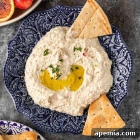 ornate blue bowl filled with tyrokafteri and bread triangles for dipping