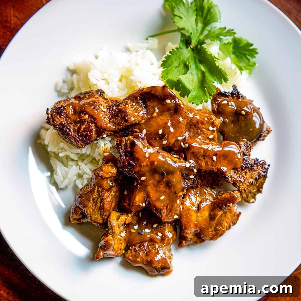 Overhead shot of Chinese Beef Curry served over rice with fresh herbs as garnish