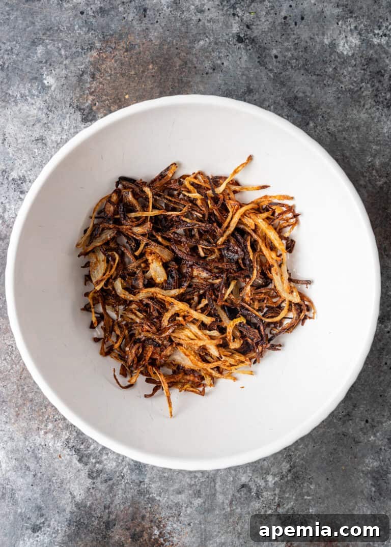 overhead process shot: crispy fried onions in white bowl