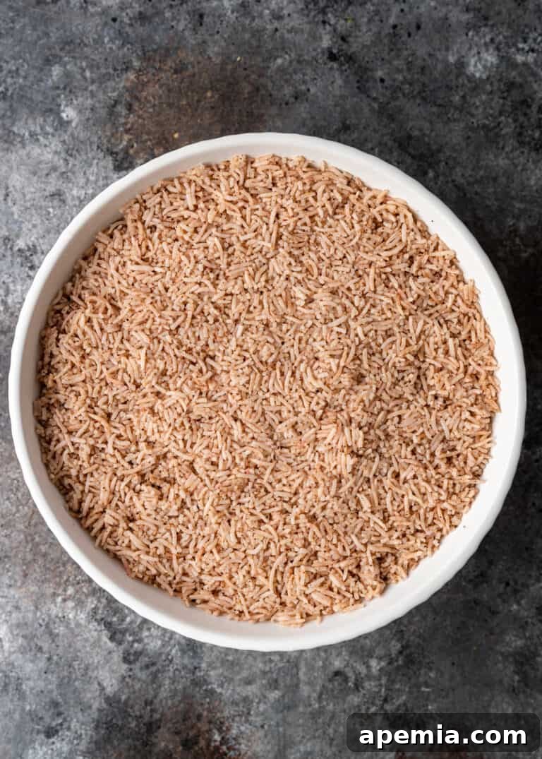 overhead process shot: adding baharat spiced basmati rice on top of the lentils