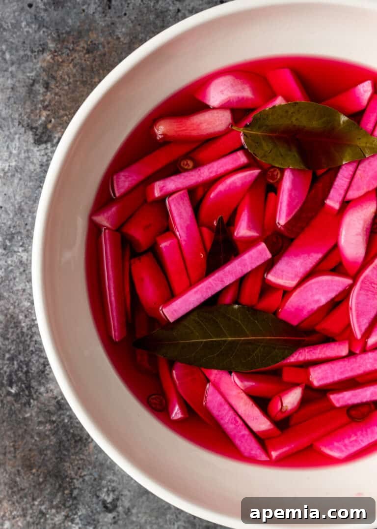 Overhead shot of a bowl of Lebanese pickled turnips on Day 5, ready to eat, surrounded by vibrant pink brine.