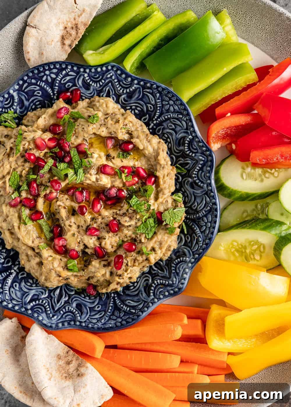 Smoky Mutabal Eggplant Dip 5 A vibrant platter of fresh raw vegetables surrounding a bowl of homemade Mutabal, ready for a delicious dipping experience.