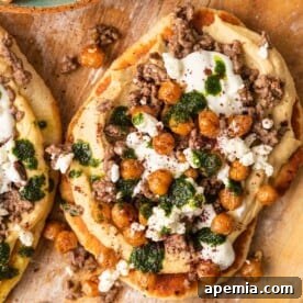 Overhead shot of a vibrant Mediterranean Flatbread Pizza with Lebanese toppings, fresh cilantro, seasoned ground meat, and feta, presented on a rustic background.