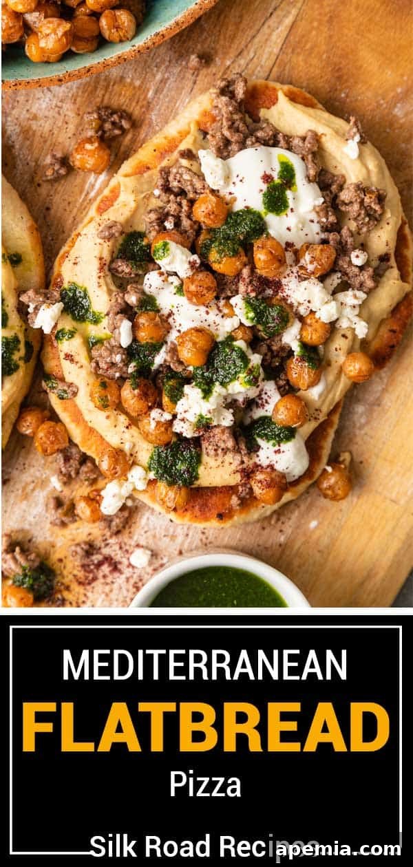 Overhead view of a stunning Mediterranean Flatbread Pizza, generously topped with creamy hummus, savory ground meat, vibrant cilantro oil, and crumbled feta cheese, ready to be enjoyed.