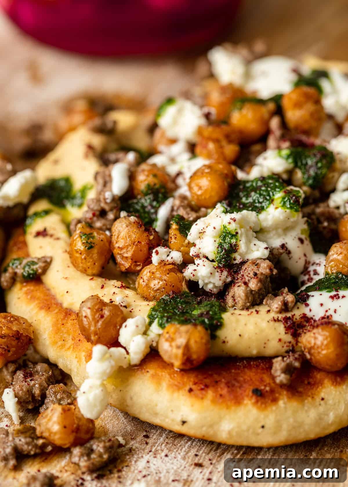 Close-up of a stovetop Mediterranean Flatbread Pizza showcasing its vibrant Lebanese toppings including spiced lamb, crumbled feta, and fresh cilantro, promising a quick and delicious meal.