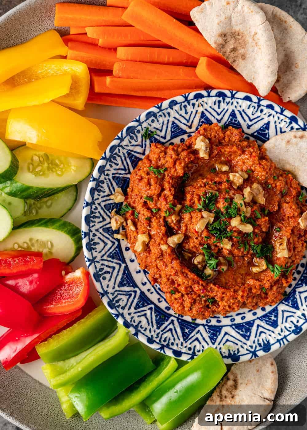 Muhammara: Mediterranean Red Pepper Walnut Dip 6 overhead: platter of raw vegetables and bowl of muhamara