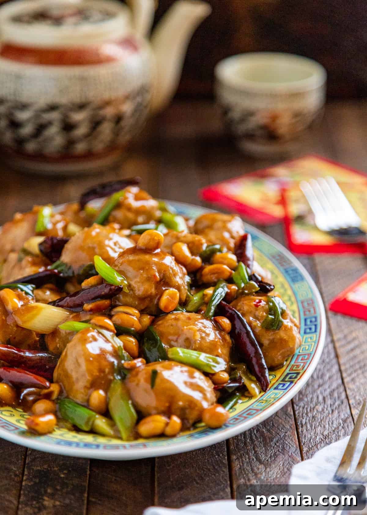 dish with spicy Chinese meatballs topped with peanuts, scallions and dried Chinese peppers