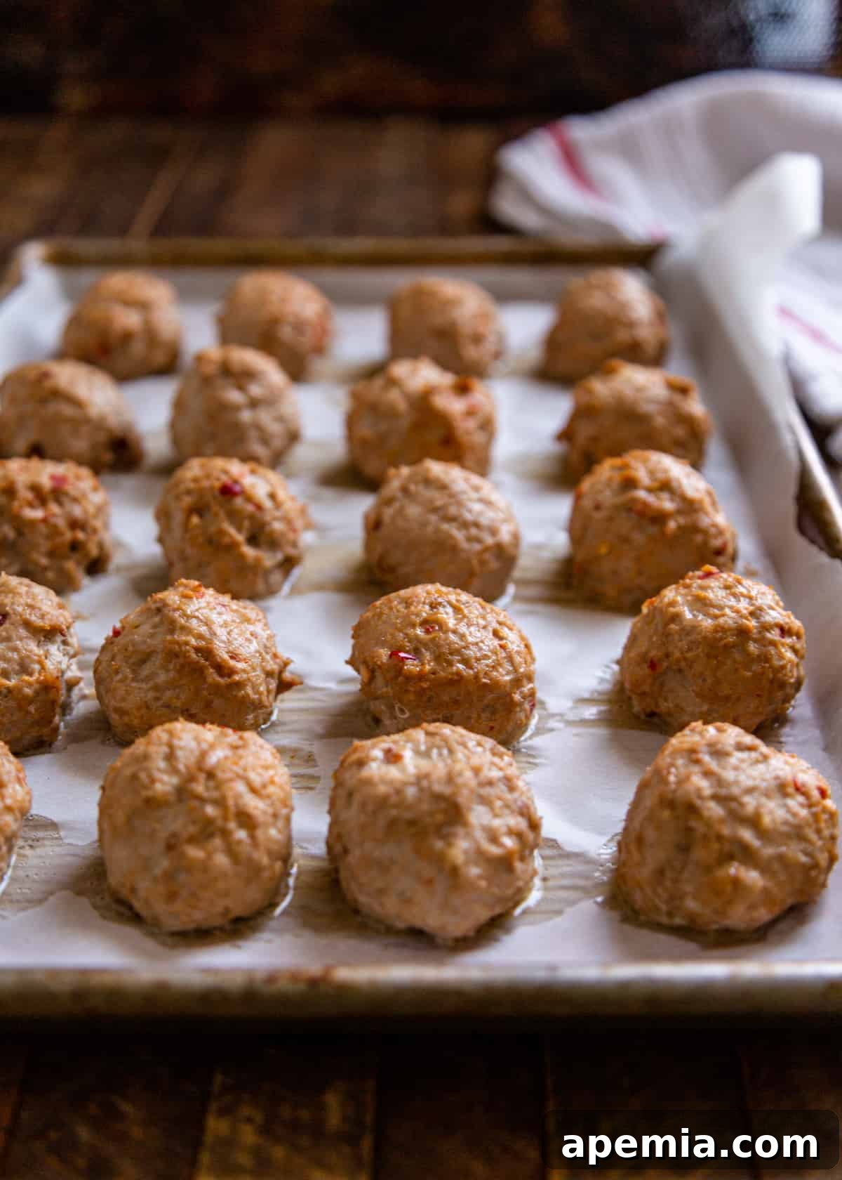 spicy ground chicken meatballs on baking sheet