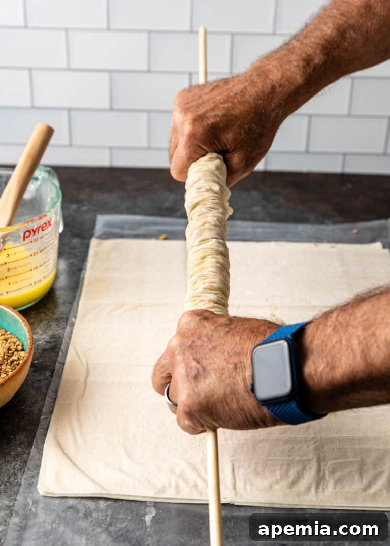 rolling phyllo pastry for saragli, pushing ends together to crinkle