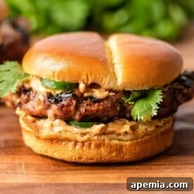 ground pork and beef burger with jalapenos and spicy peanut sauce on soft bun