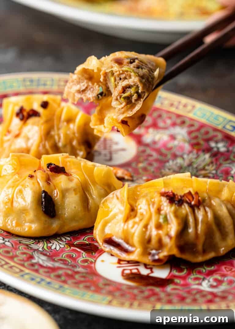 using chopsticks to pick up a single potsticker from a communal platter