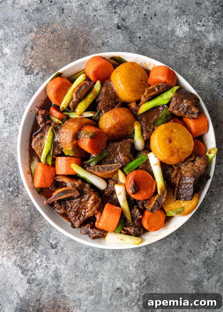 short ribs with carrots and potatoes in white bowl