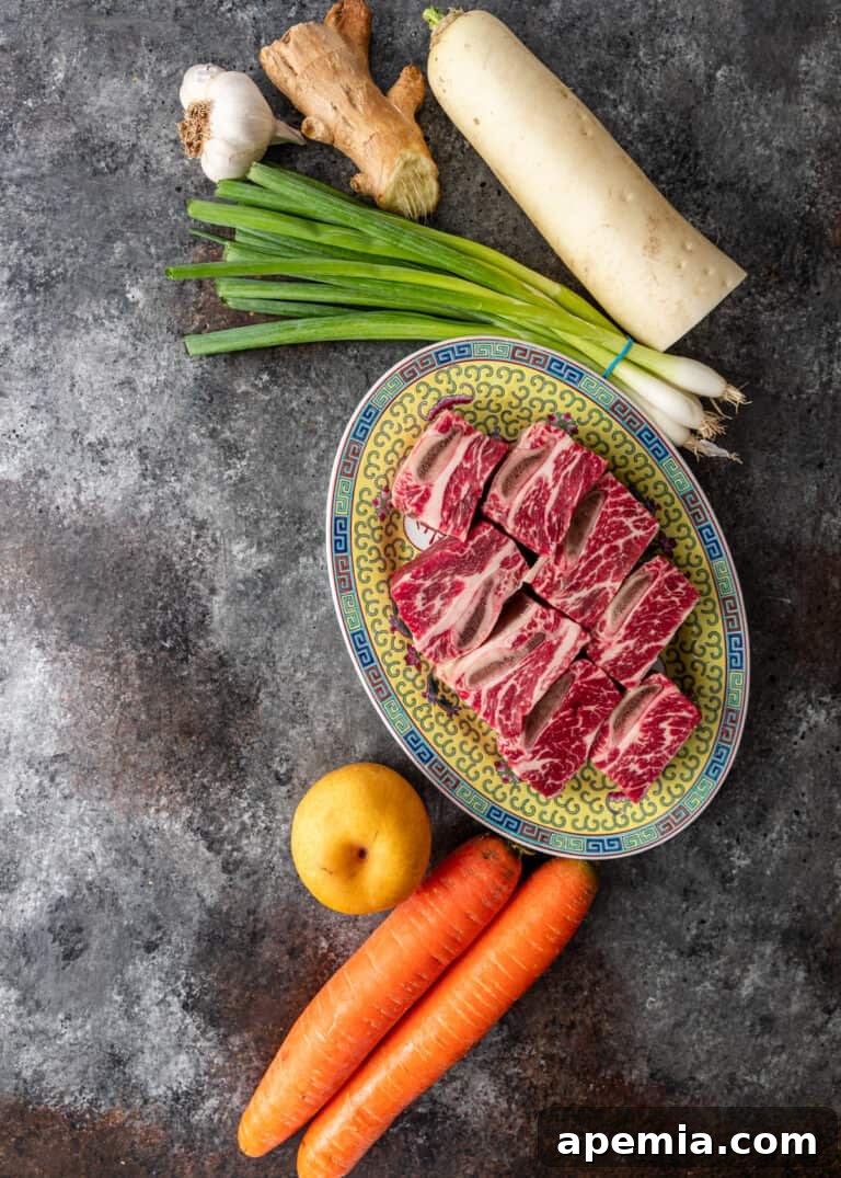 overhead: uncooked beef short ribs and root vegetables for galbi jjim recipe